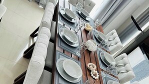 A dining table set with plates, glasses, and a centerpiece. - Beautiful apartment 3 blocks from the beach (Mazatlan)