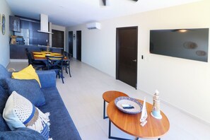 Ein modernes Wohnzimmer mit einer Couch, einem Couchtisch und einem Essbereich mit Stühlen und einem Tisch.