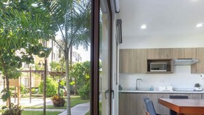 Una cocina moderna con microondas integrado, armarios de madera y un comedor con mesa y sillas.