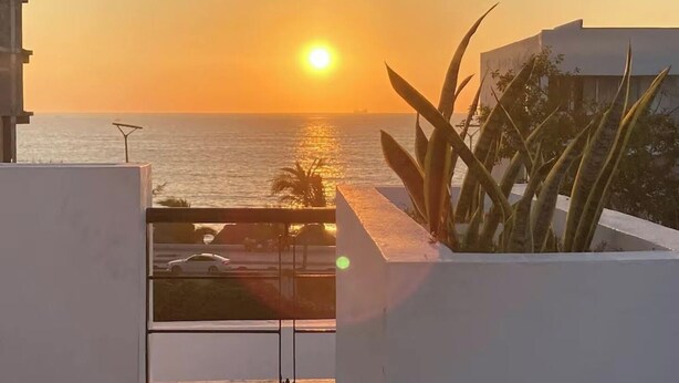 A balcony with a view of the ocean at sunset. - Roma Suite A Malecon de Mazatlán (Mazatlán)