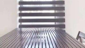 A room with a wooden table, a window with horizontal blinds, and a wall-mounted decorative item. - Roma Suite A Malecon de Mazatl án (Mazatlán)