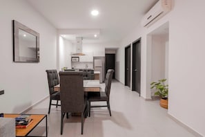 Eine moderne Wohnung mit Essbereich, Küche und einem Flur, der zu einer Tür führt.