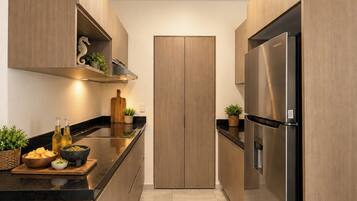 Une cuisine moderne avec des meubles en bois, un réfrigérateur en acier inoxydable et un plan de travail noir.