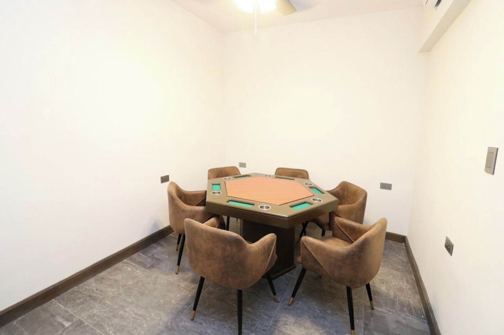 Una sala de conferencias con una mesa hexagonal, seis sillas y piso alfombrado.