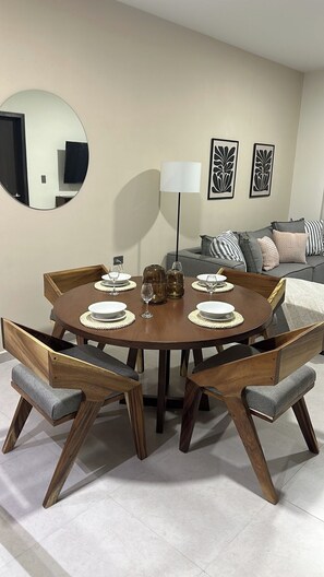 Ein Essbereich mit einem runden Holztisch, sechs Stühlen und einer Stehlampe.