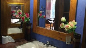 Ein Badezimmer mit Waschbecken, Spiegel und zwei Wandleuchten.