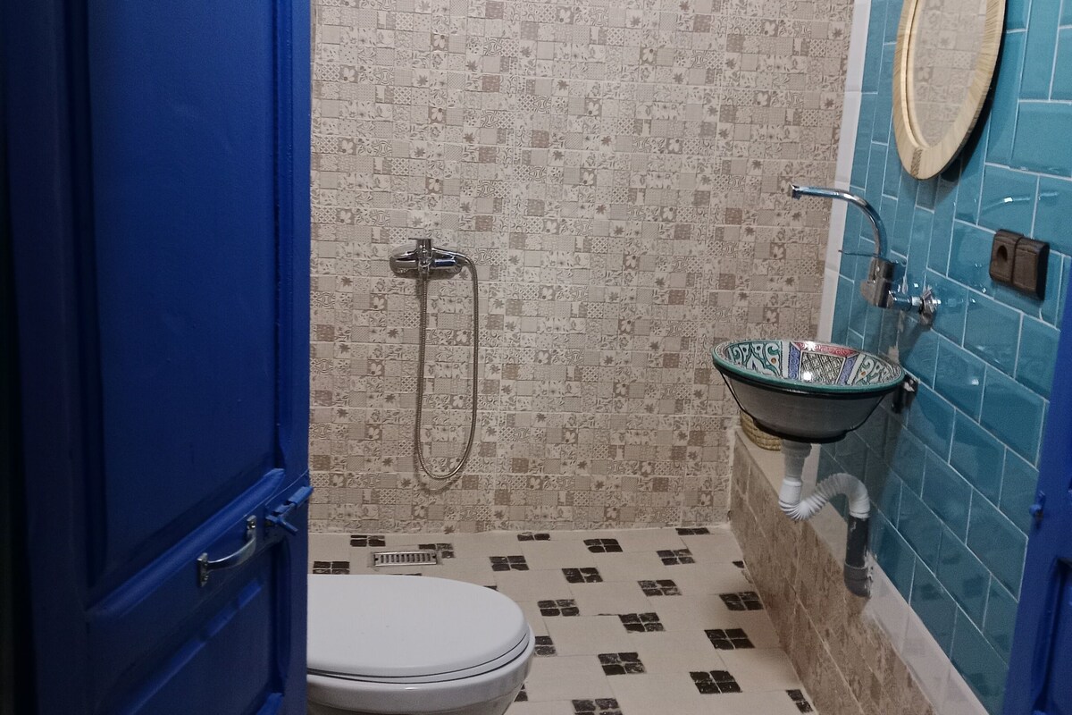 A bathroom with a toilet, a sink, and a shower.