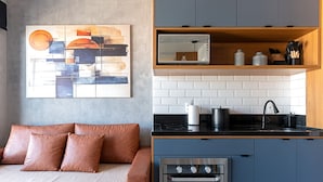 Una cucina moderna con forno integrato, macchina del caffè e microonde sul piano di lavoro.