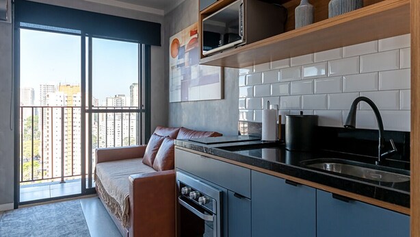 Una cucina moderna con forno integrato, lavello e finestra con vista sulla città.