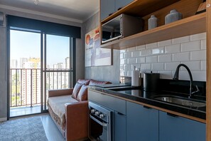 Eine moderne Küche mit Backofen, Spüle und Fenster mit Blick auf eine Stadtlandschaft.