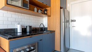 Una cucina moderna dotata di forno a microonde, fornello e frigorifero.
