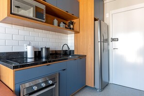 Une cuisine moderne équipée d’un four à micro-ondes, d’une cuisinière et d’un réfrigérateur.