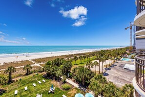 Ein Resort mit Blick auf den Strand, Palmen und einem Poolbereich.