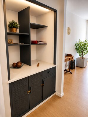 Ein modernes Interieur mit einer eingebauten Regallösung, einem kleinen Tisch und einer Topfpflanze.