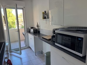 Eine moderne Küche mit Mikrowelle, Toaster und Fenster zur Außenwelt.