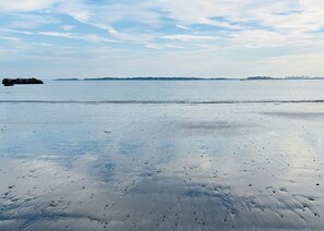 A beach with a calm sea and distant city skyline. - Quiet, homey & private 3BR in Swampscott. 7-min walk to beach. (Swampscott)