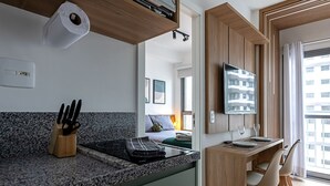 Moderni keittiö, jossa on graniittitasot, sisäänrakennettu liesi ja puinen astiateline.
