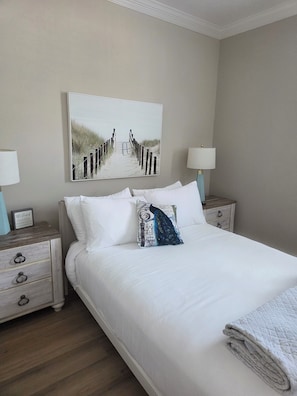 A neatly made bed with white linens, a decorative pillow, and a folded blanket. There are two bedside tables with lamps and a framed picture on the wall. -  Shore Getaway. 3-bedroom  house in Fantastic Atlantic City very close Boardwalk (Atlantic City)