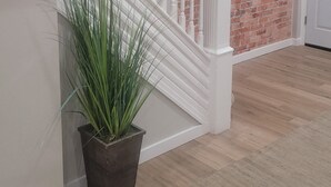 Eine Treppe mit weißen Balustraden, einer Ziegelwand und einem Blumentopf.