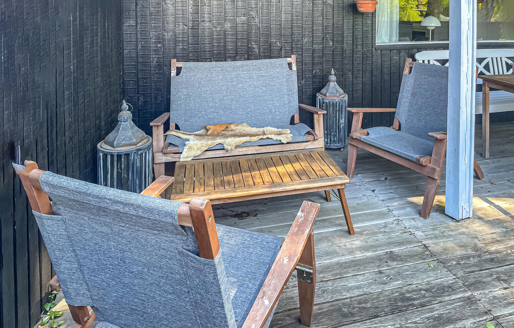 A wooden deck with a rustic outdoor seating area featuring two chairs and a table.