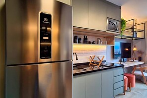 Eine moderne Küche mit einem Edelstahl-Kühlschrank, einem Einbauofen und einer Spüle.