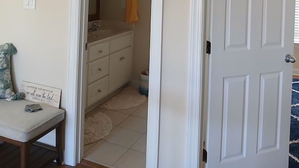 A room with a white door, a mirror, a sink, and a towel rack. - Cozy 2 bedrooms in Evans for Travelling Medical Professionals (Evans)