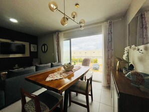 A dining area with a wooden table, chairs, and a chandelier. - Cozy 2-bedroom apartment in fantastic Punta Cana with AC (Punta Cana)