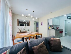 Una sala de estar moderna con una mesa de comedor, sofá y área de cocina.
