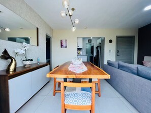 Una cocina moderna con una mesa de comedor de madera, sillas y una araña.