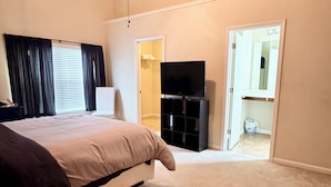 A bedroom with a bed, a TV, a ceiling fan, and a walk-in closet. - 4-BDRM • FIFA Stadium • Airport • Downtown ATL • Six Flags • Wolf Creek Concerts (Atlanta)