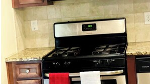 A kitchen with a stainless steel microwave, oven, and stove, wooden cabinets, and a granite countertop. - 4-BDRM • FIFA Stadium • Airport • Downtown ATL • Six Flags • Wolf Creek Concerts (Atlanta)