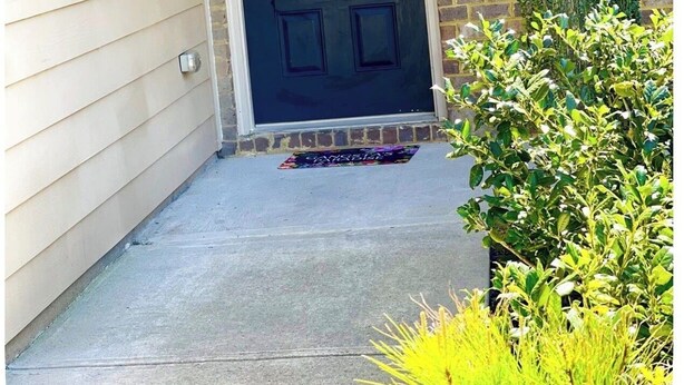 A house with a black front door, a brick wall, a small window, and a potted plant. - 4-BDRM • FIFA Stadium • Airport • Downtown ATL • Six Flags • Wolf Creek Concerts (Atlanta)