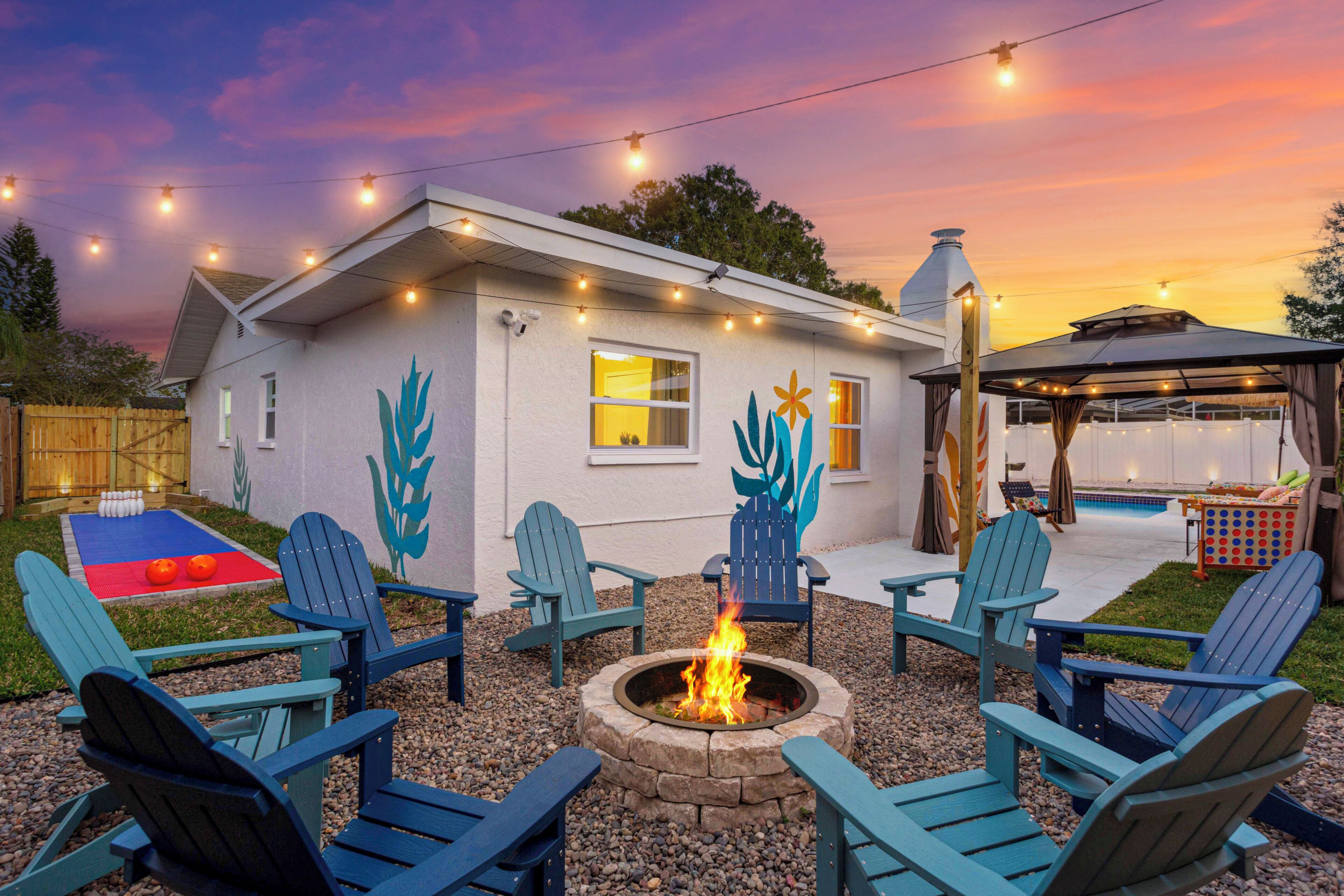 A house with a fire pit, outdoor seating, and a pool area.
