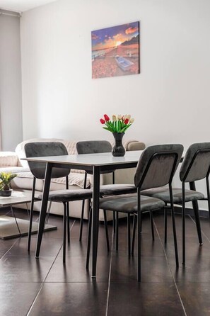 Un comedor con una mesa, sillas y un jarrón de flores.