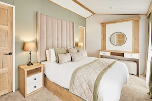 A bedroom with a bed, bedside tables, a dresser, a mirror, and a door. - Host Stay Rose Lodge (York)
