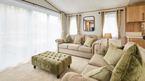 A living room with a sofa, ottoman, and a lamp. - Host Stay Rose Lodge (York)