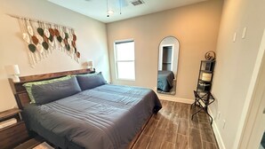 A bedroom with a bed, a ceiling fan, a window, a mirror, and a nightstand. - 3BR, 3.5Bath Home Near TMC, Downtown, Museums, NRG,Toyota CT, Discovery Green (Houston)