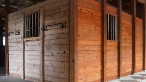 Un edificio in legno con inferriate e un cancello in metallo.