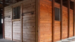 A wooden building with barred windows and a metal gate. - Superior Queen Two-Bedroom Cottage - no pets (Bronson)