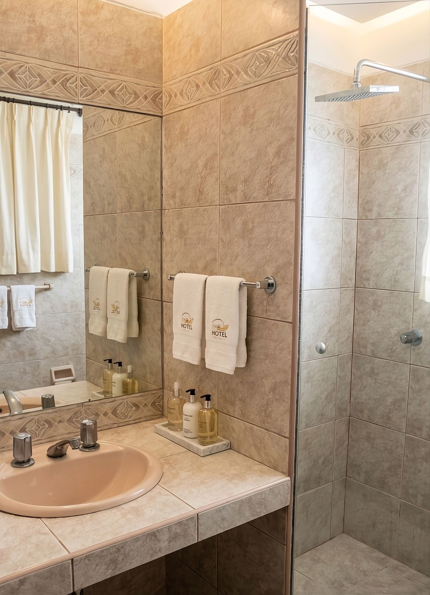 A bathroom with a sink, mirror, towel rack, shower, and toiletries.