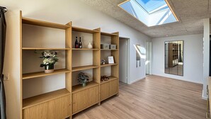 A room with a skylight, wooden shelving, and a view through a glass door. - Gorgeous home in Haderslev with sauna (Haderslev)