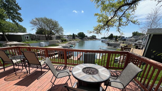 Eine Terrasse mit Tisch und Stühlen mit Blick auf eine Marina und Boote.