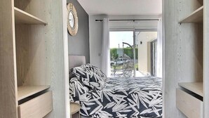 Ein Schlafzimmer mit einem Bett, einem Sessel und einem Kleiderschrank.