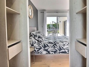A bedroom with a bed, a chair, and a wardrobe. - La Maison de Sophie - PLOUHA (PLOUHA)