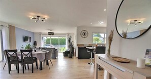 A modern kitchen with a dining area, large windows, and a mirror. - La Maison de Sophie - PLOUHA (PLOUHA)
