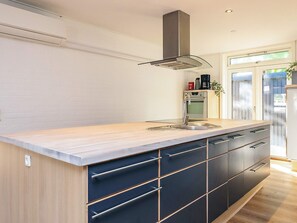Eine moderne Küche mit Spüle aus Edelstahl, Backofen und Dunstabzugshaube.
