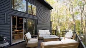 A deck with outdoor furniture, a grill, and a sliding glass door leading to an interior dining area. - New listing! 4BR Holland Getaway Near Lake Michigan Beaches & Kirk Park (West Olive)