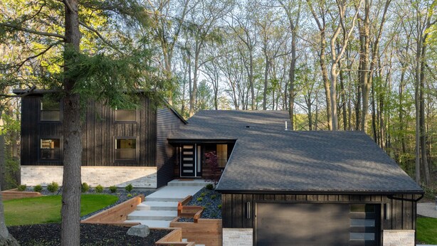 A modern house with a large garage, a stone pathway leading to the entrance, and a well-maintained garden. - New listing! 4BR Holland Getaway Near Lake Michigan Beaches & Kirk Park (West Olive)