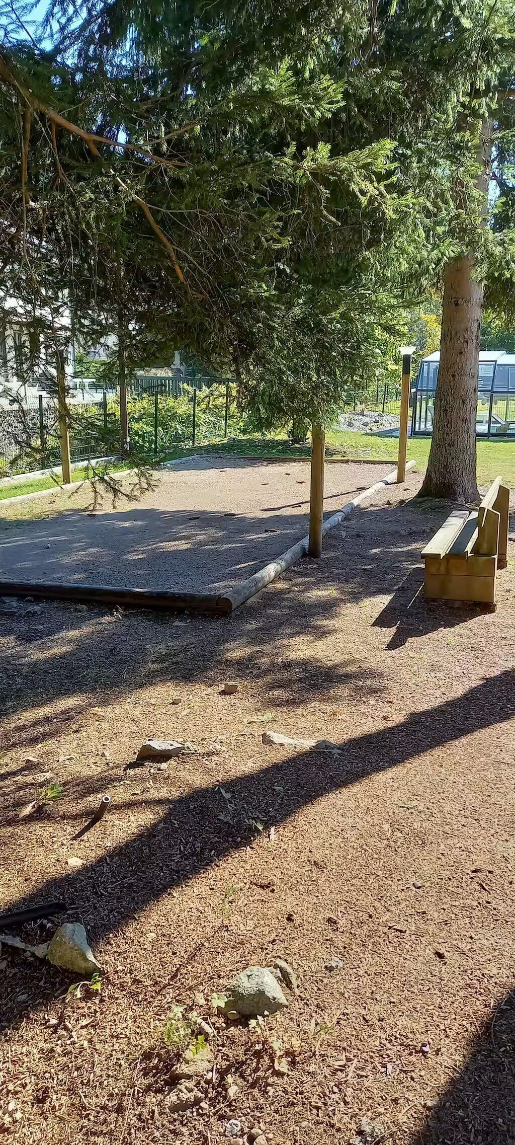 A park with a playground, a bench, and a tree.
