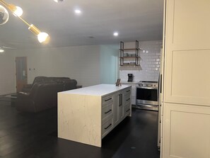 Eine moderne Küche mit einer zentralen Kochinsel, Edelstahlgeräten und einem Essbereich mit einer Ledersitzgruppe.